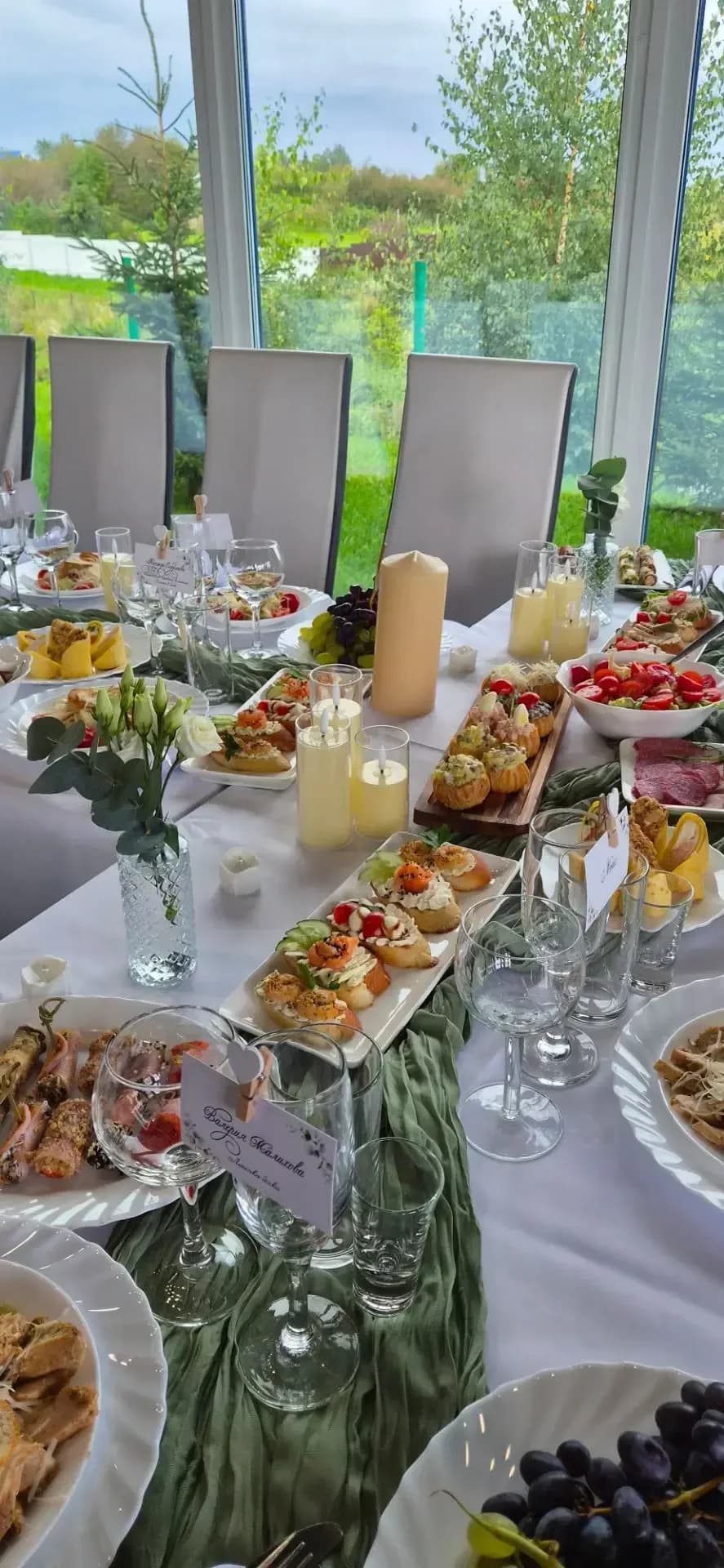 Сервированный банкетный стол с закусками и свечами